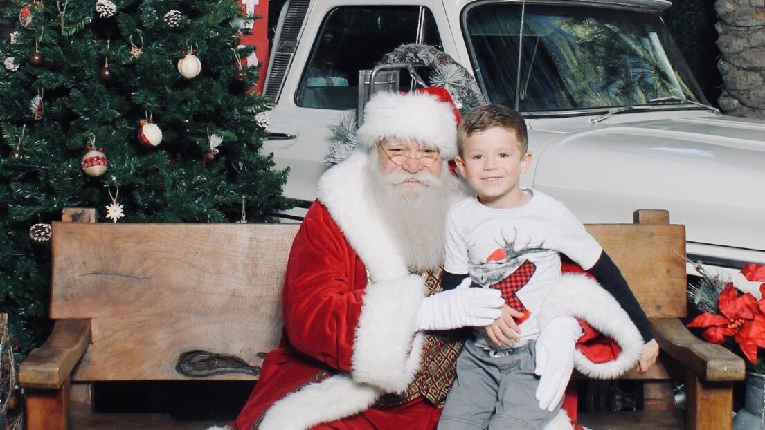 Child sitting on Santa's lap, in front of a truck at Scottsdale Quarter.