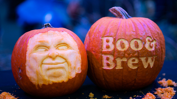 two pumpkins one with carved face and one carved boo & brew