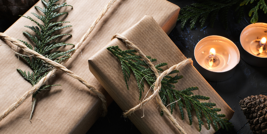 Green with white text saying "the ultimate holiday gift guide" and an image of two brown paper packages with twin and a pine branch and two small candles