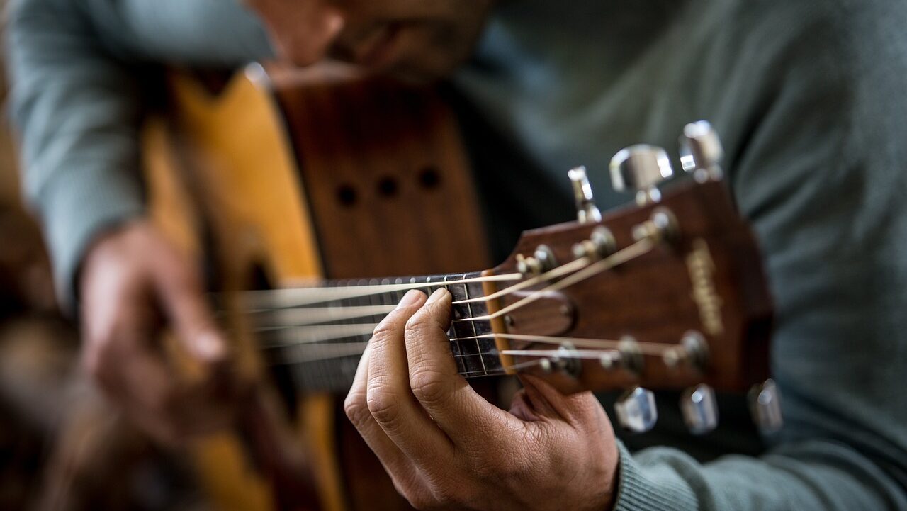 close up view of a person playing a guitar