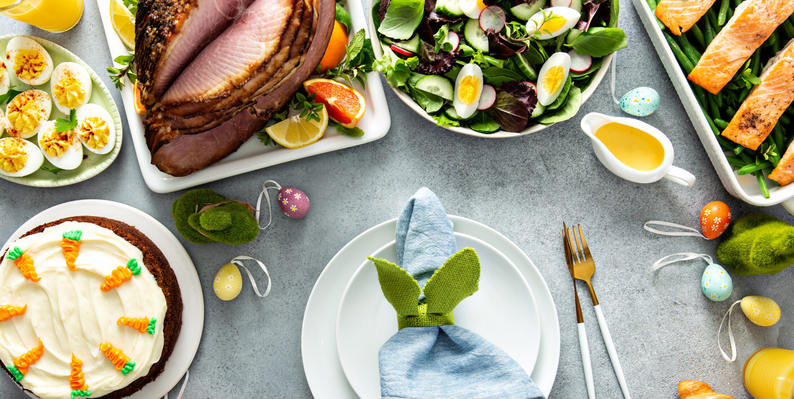 Big traditional Easter brunch with ham, quiche lorraine and carrot cake and place setting