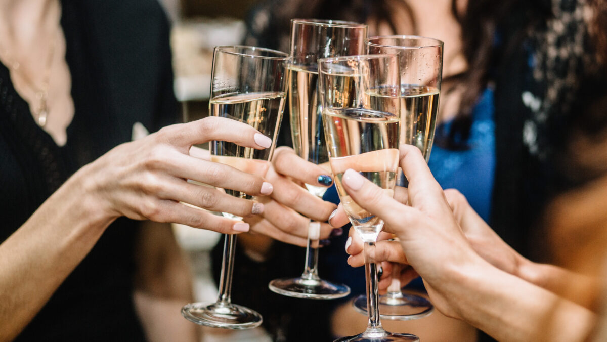 Group of partying girls clinking flutes with sparkling wine at a bachelorette party