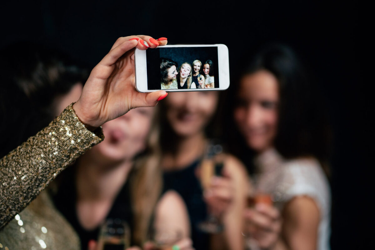 Women night out at a bachelorette party, celebration. Group of girls drinking champagne, taking selfie in night club.