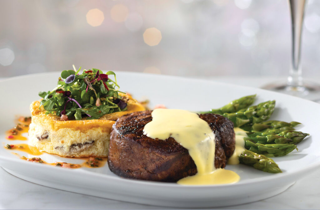 Filet, frittata, and asparagus, plated with a sauce.