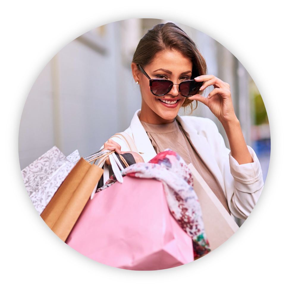 woman with shopping bags tilting her sunglasses down