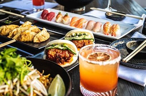 A table full of assorted sushi and happy hour appetizers and drinks from Obon.