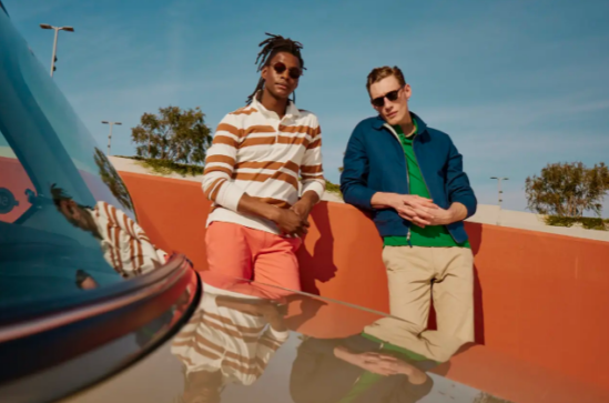 Two men in casual clothing next to a car