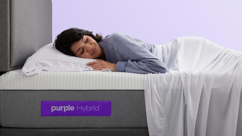 a woman lying down on a purple mattress