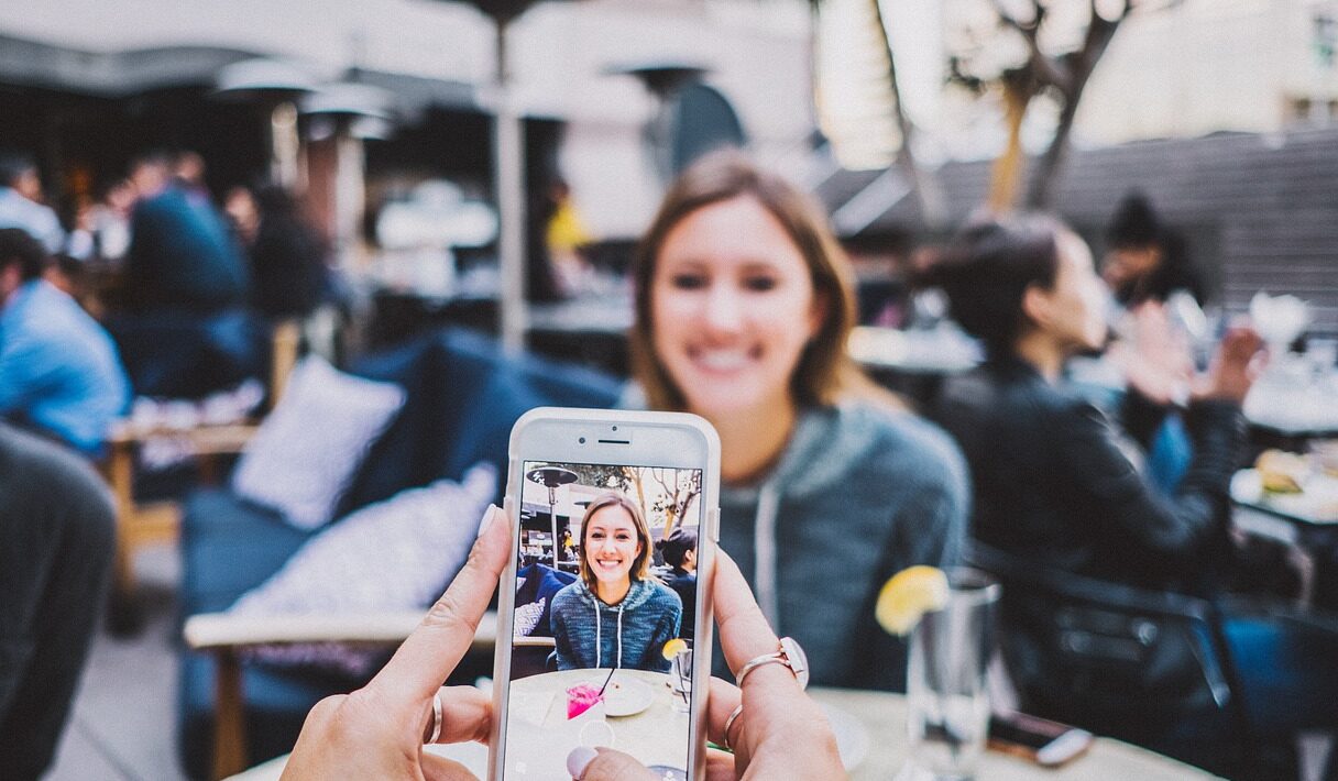 A person taking a photo of someone on their iphone