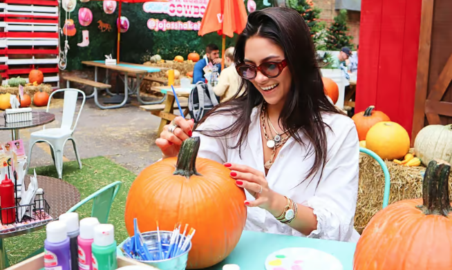 A woman painting a pumpkin