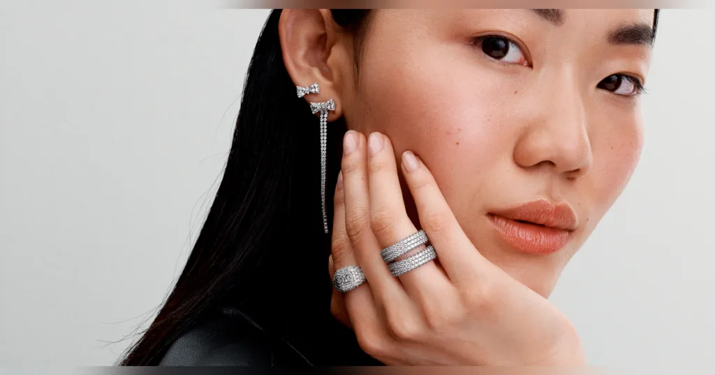 A woman wearing rings and earrings.