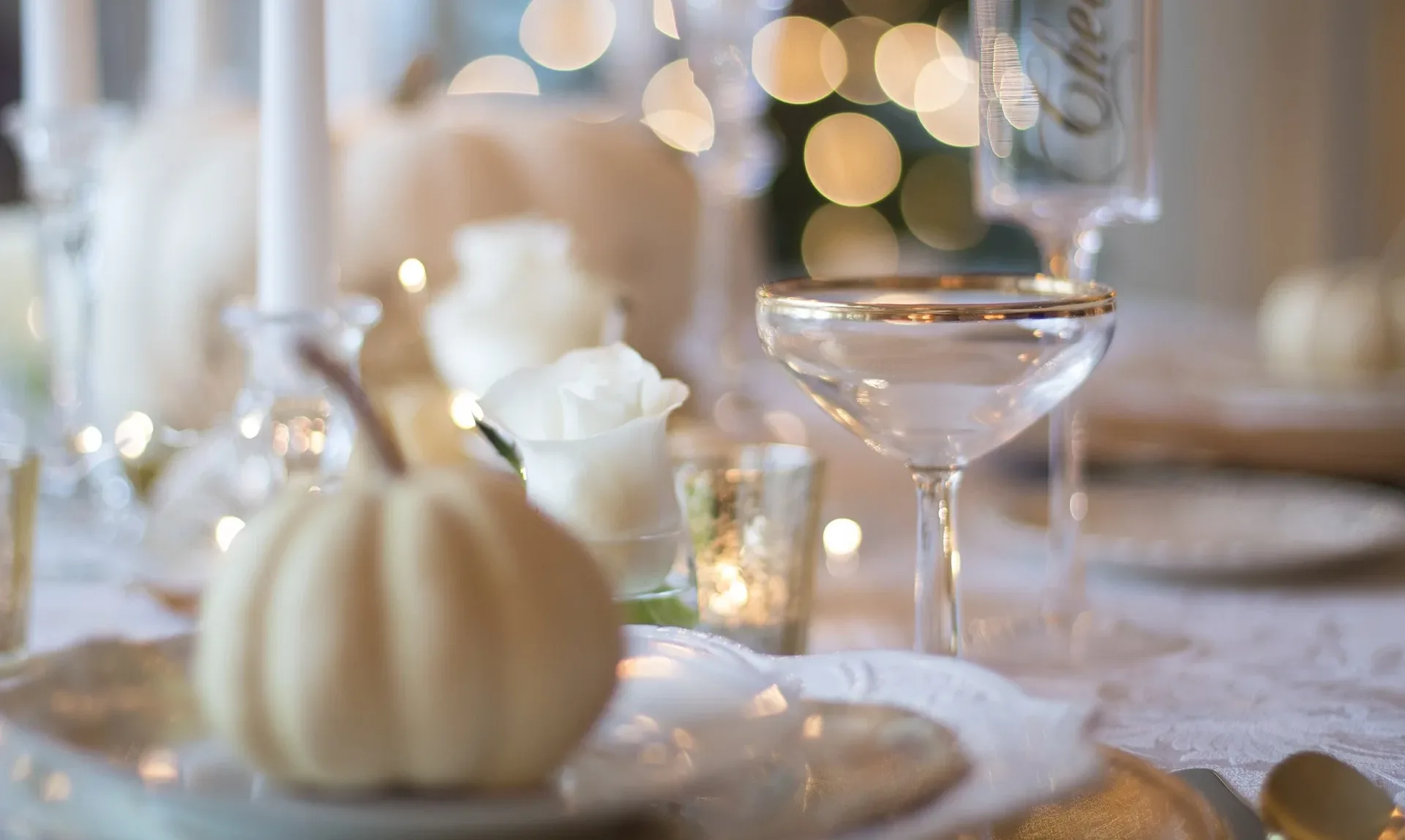 A white table setting with a white pumpkin