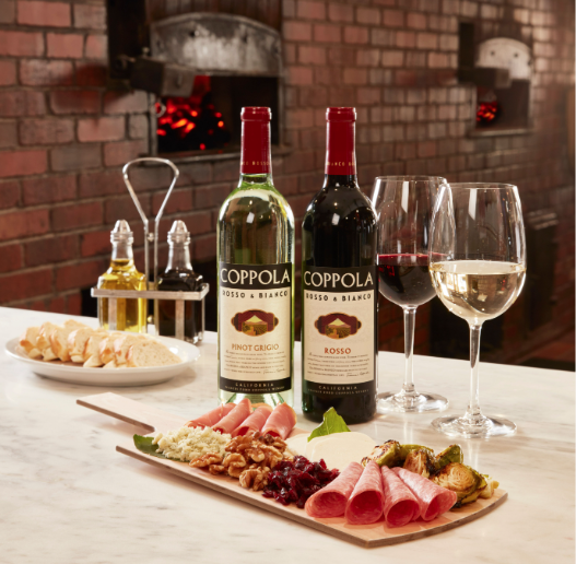 a charcuterie board with bottles and glasses of wine