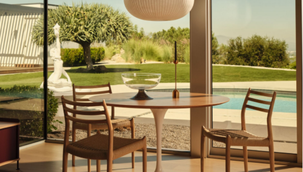 A dining table and chairs next to a window