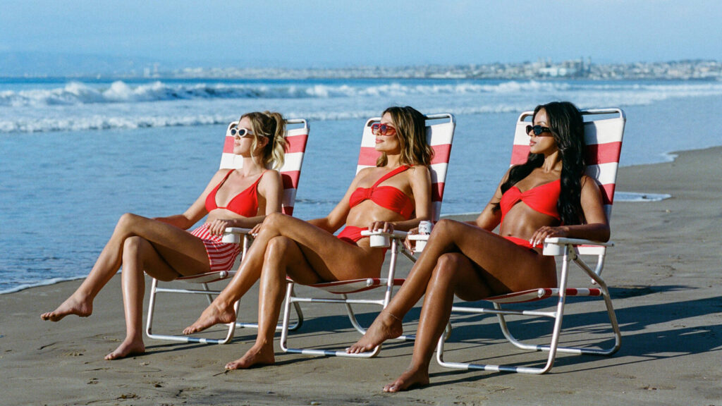 Three women lounging in chairs on the beach