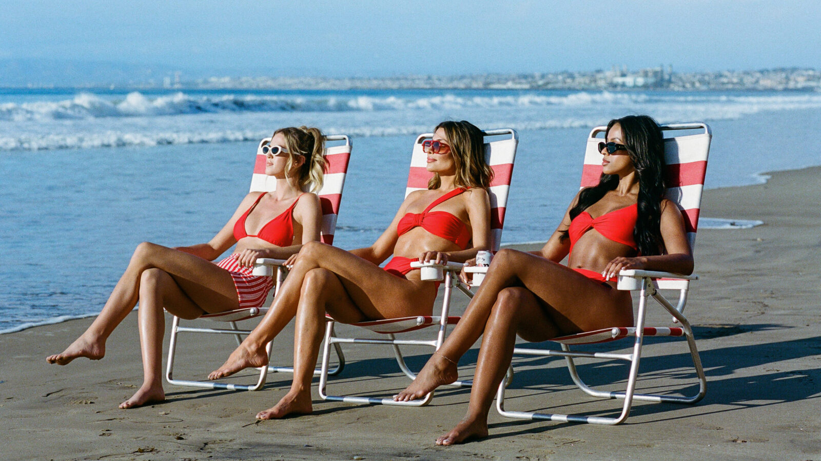 Three women lounging in chairs on the beach