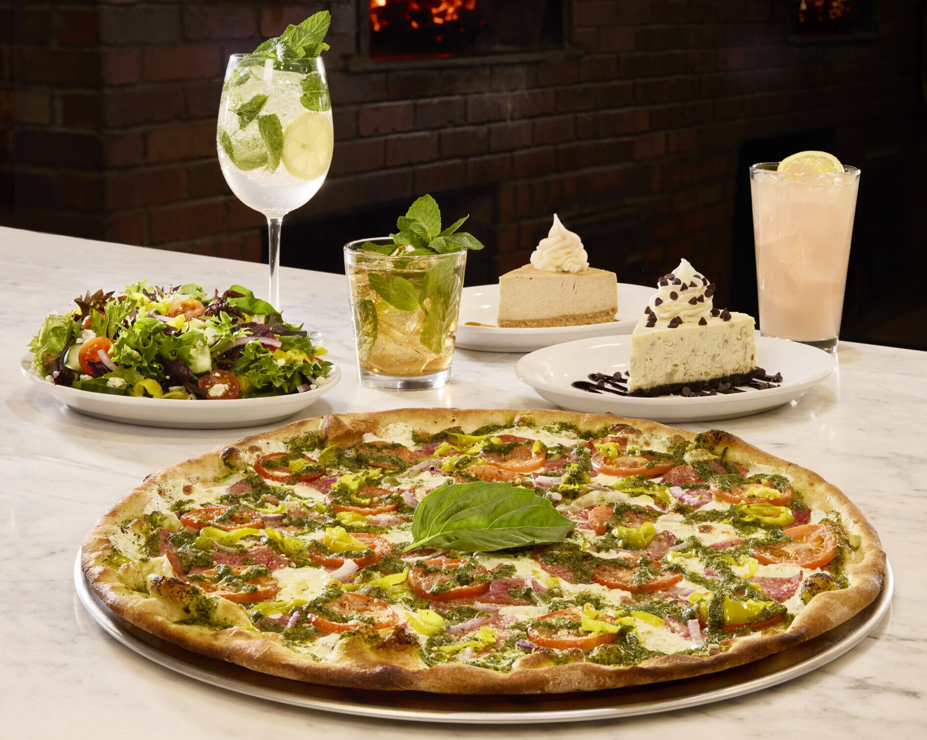 An assortment of food and drinks with a pizza