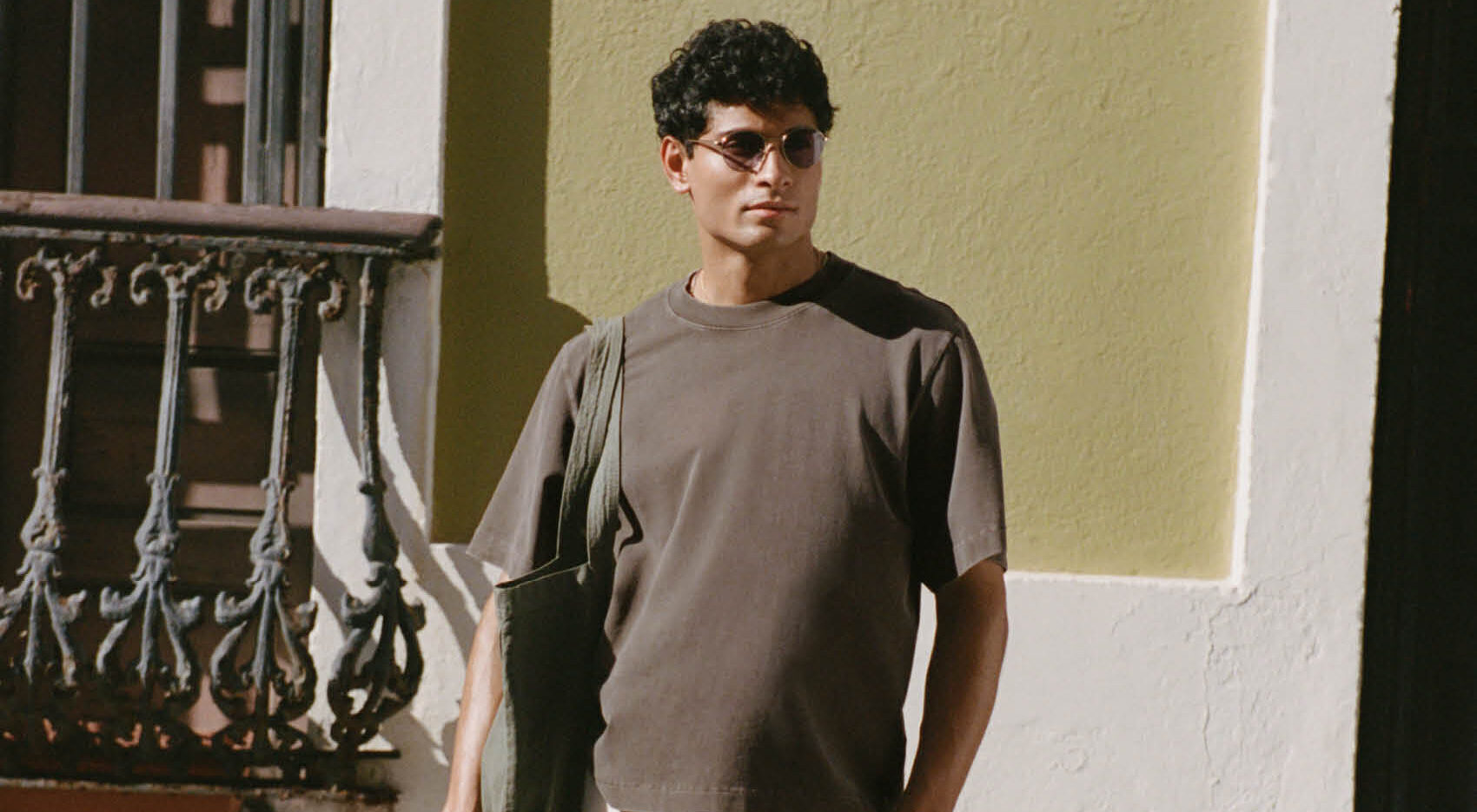A man standing outside wearing a t-shirt and sunglasses