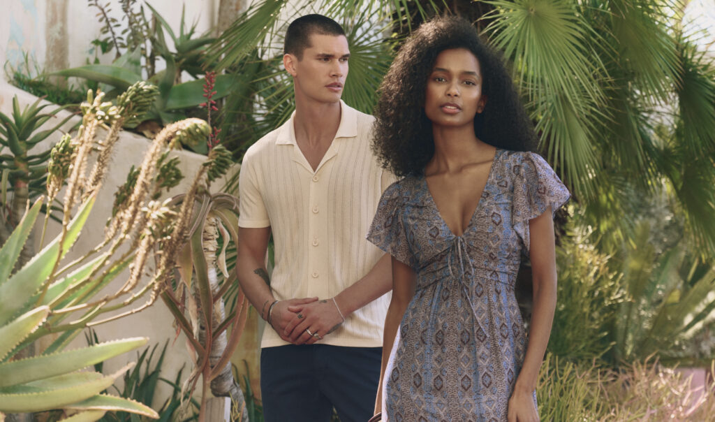 A couple in summer clothing, standing outside
