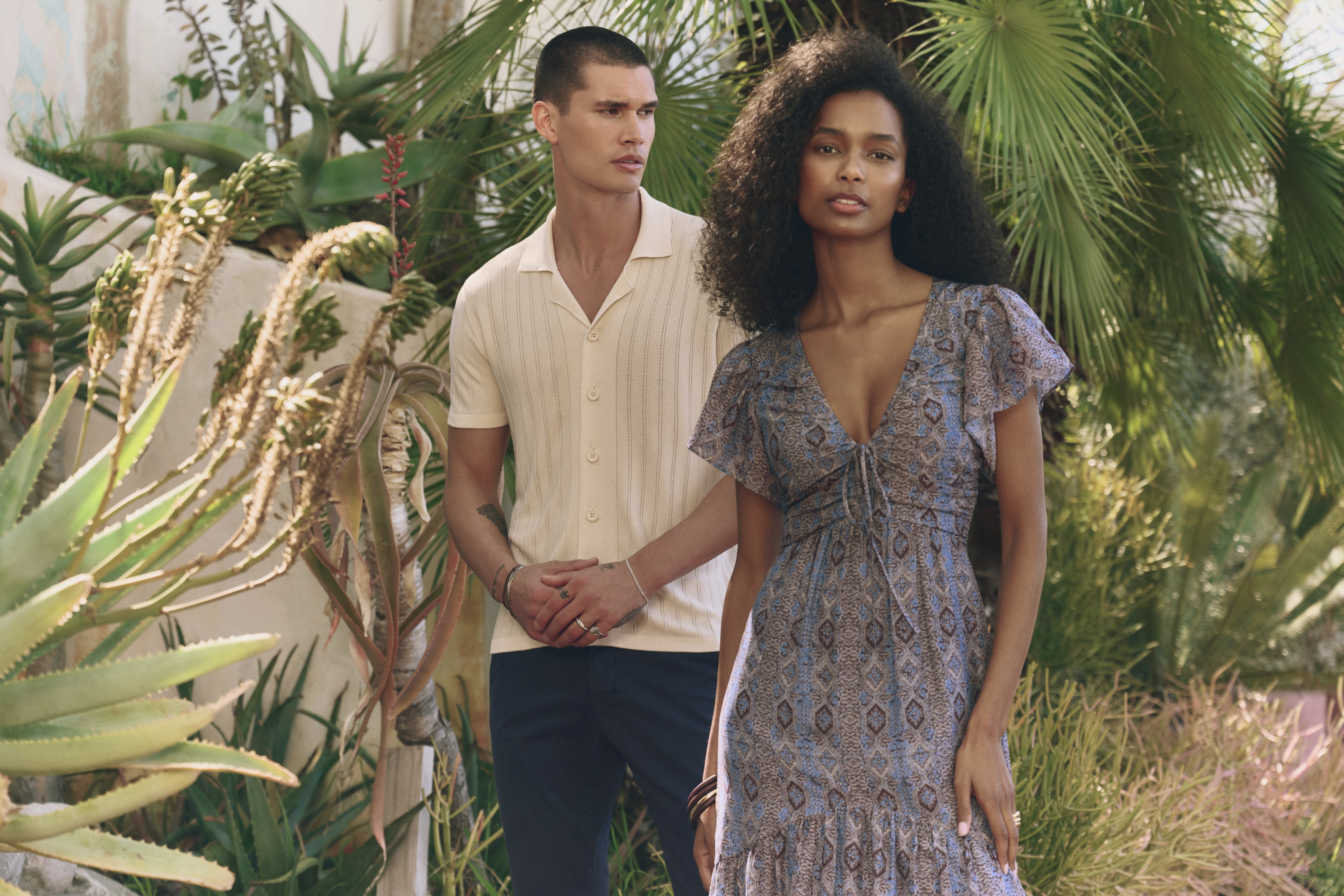 A couple in summer clothing, standing outside