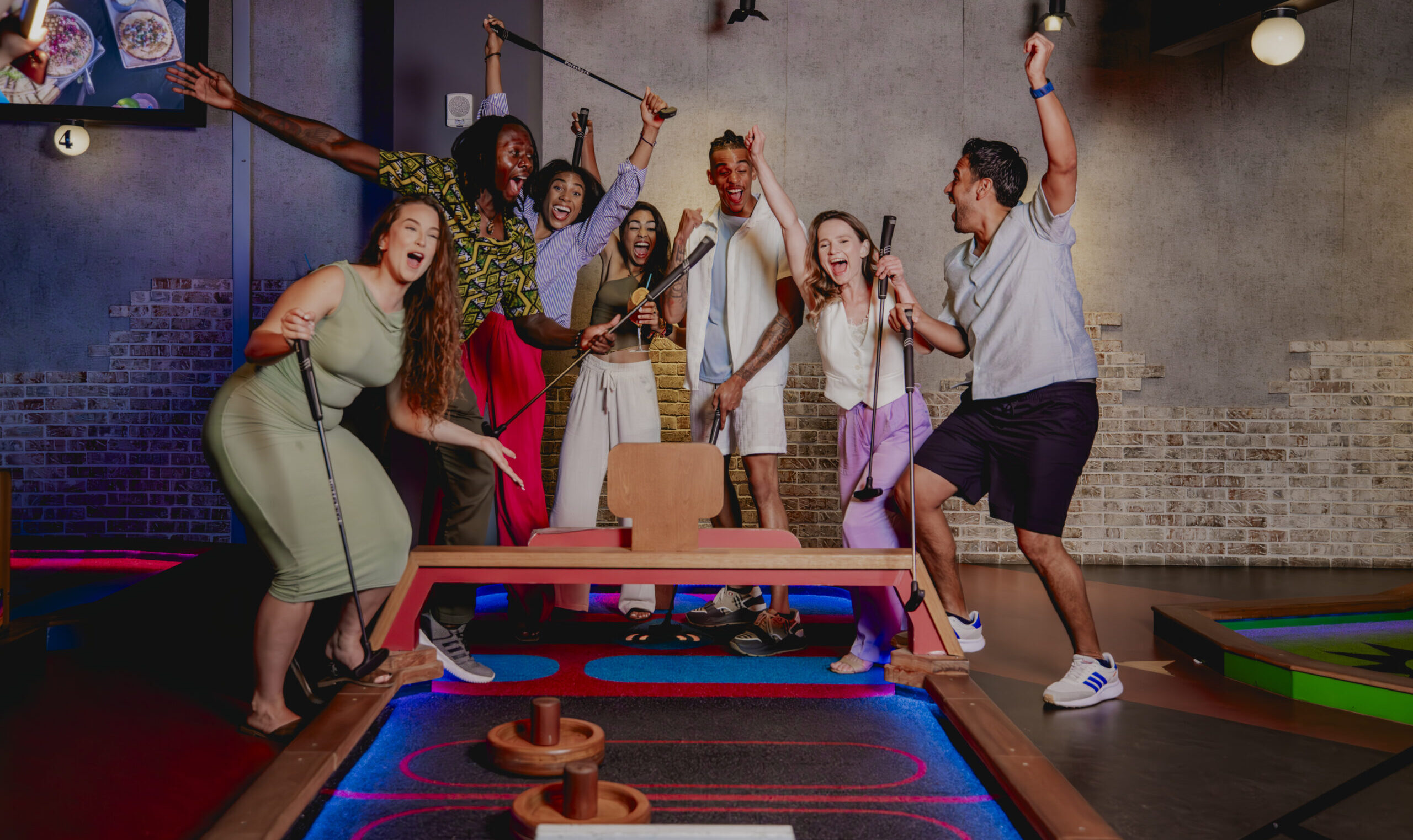 A group of friends playing mini golf at Puttshack