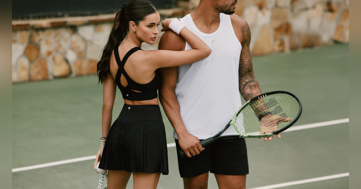 A couple on a tennis court wearing athletic apparel