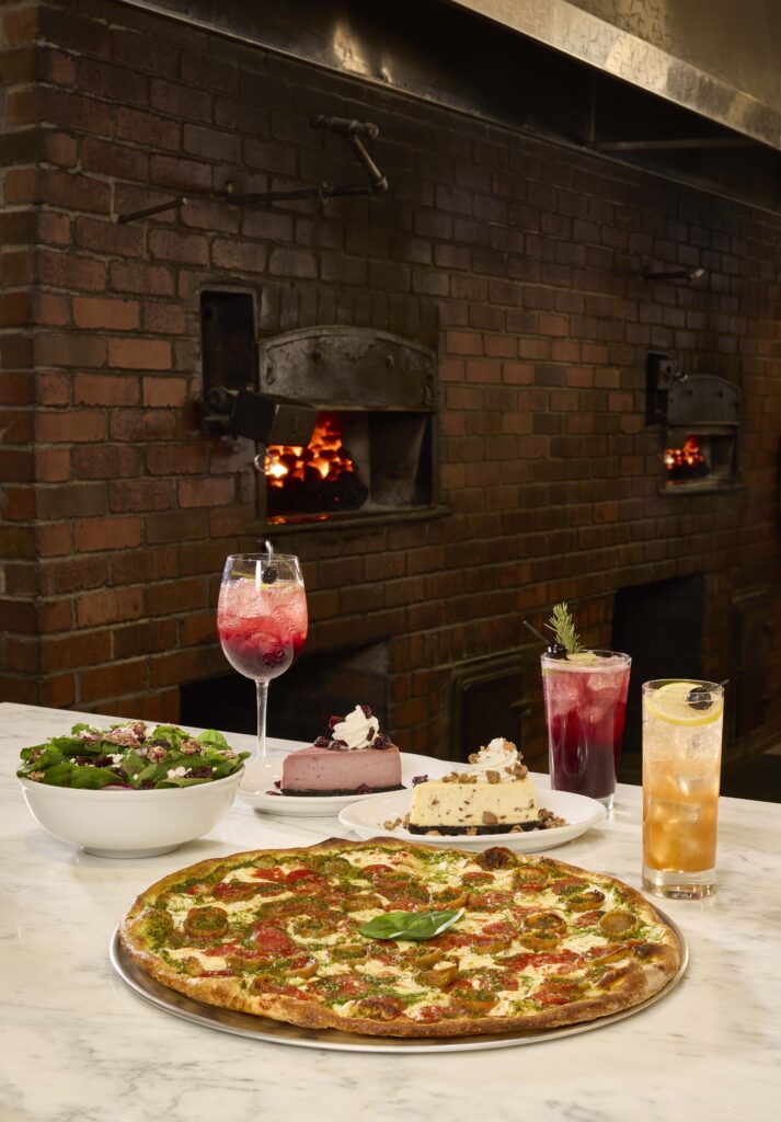 Pizza, cheesecake, salad, and drinks on a table