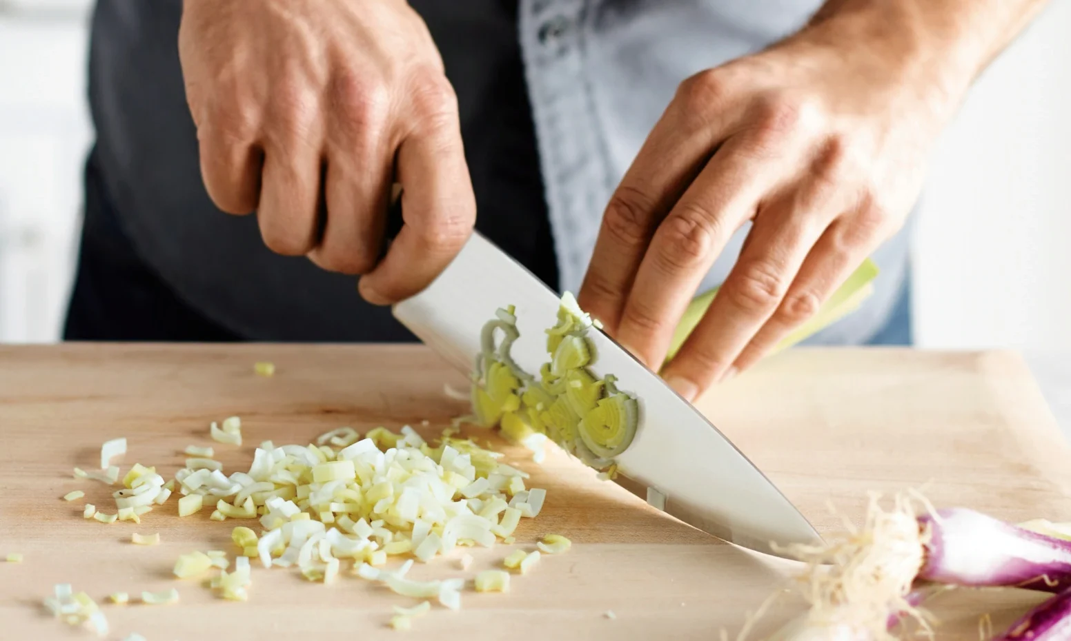 a person chopping shallots with a knife