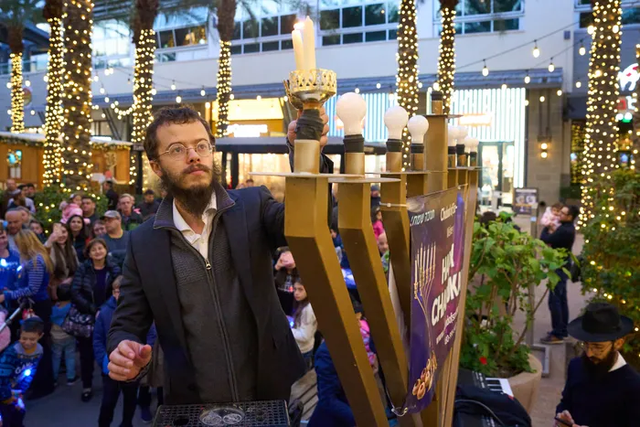 Rabbi lighting a giant menorah at Scottsdale Quarter