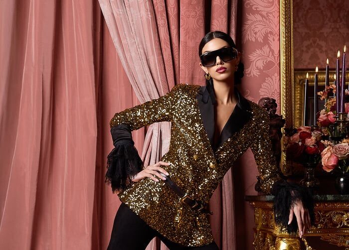 A woman in a sparkly jacket and sunglasses