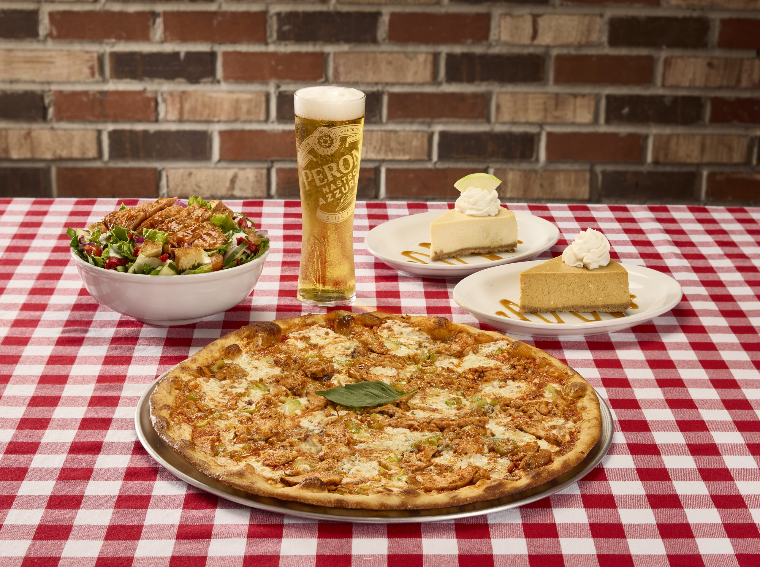 Buffalo chicken pizza, salad, cheesecake, and beer