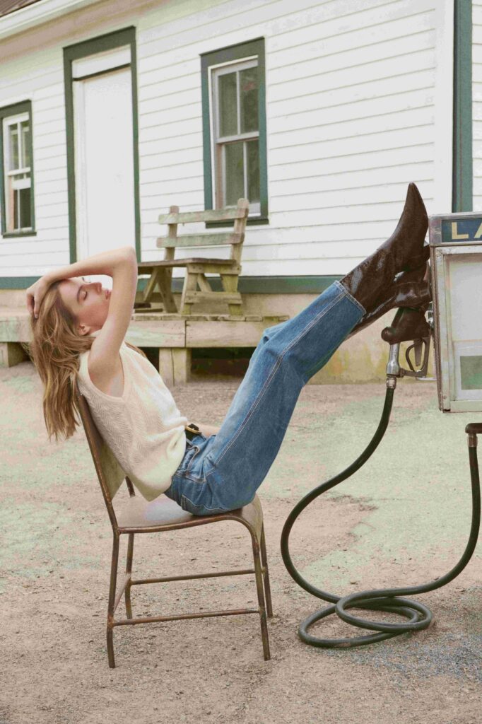 a woman kicked back in a chair wearing cowboy boots